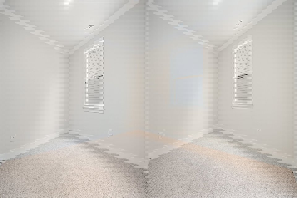 A room with a window and carpet.