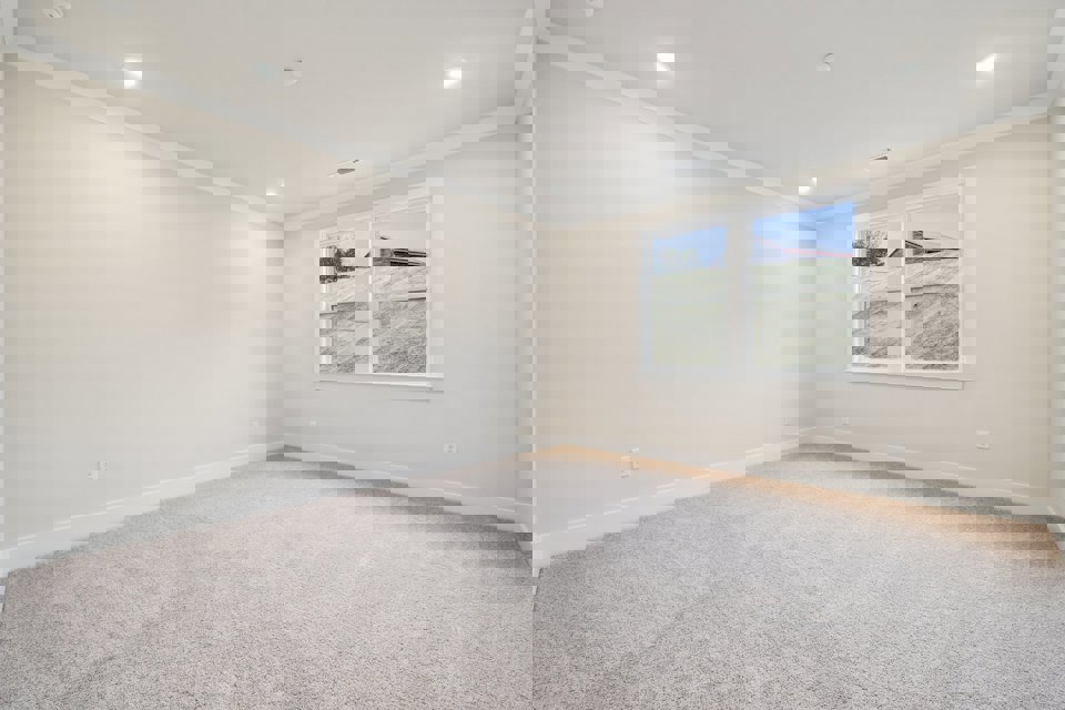 A room with a window and a carpet.