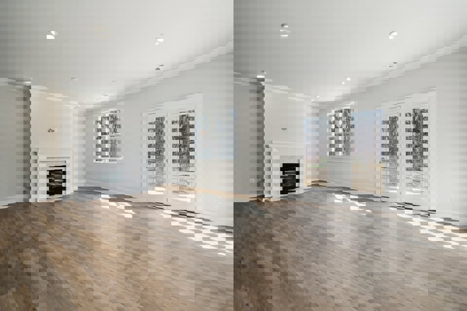 A room with a fireplace and wood floors.