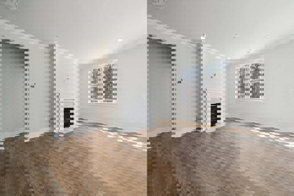 A room with a fireplace and wood floors.