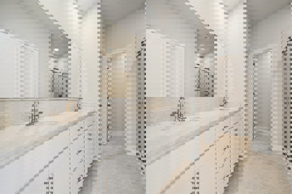 A bathroom with white cabinets.