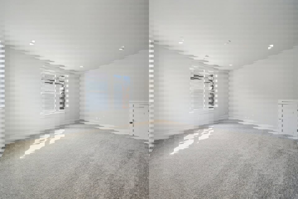 A room with a carpet and a window.