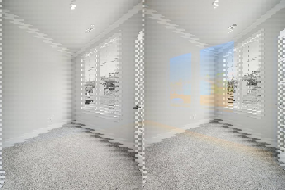 A room with a window and a carpet.