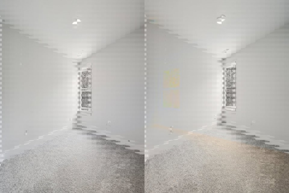 A room with a window and carpet.