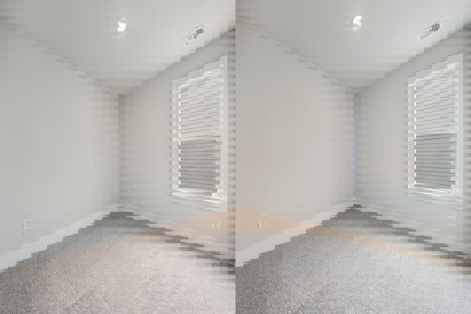 A room with a window and carpet.