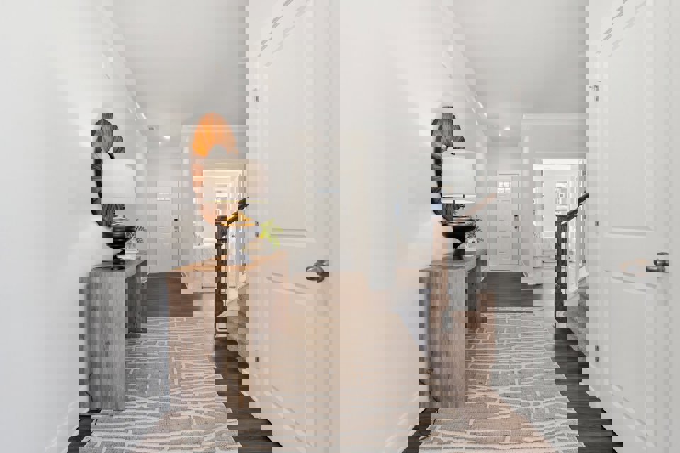 A hallway with a lamp and a mirror.