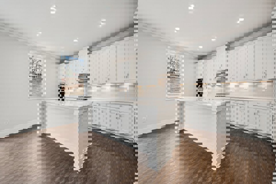 A kitchen with white cabinets.