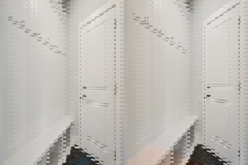 A white door next to a white wall.