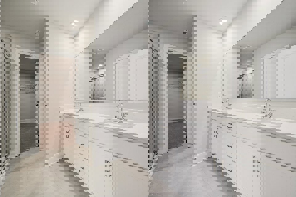 A bathroom with white cabinets.