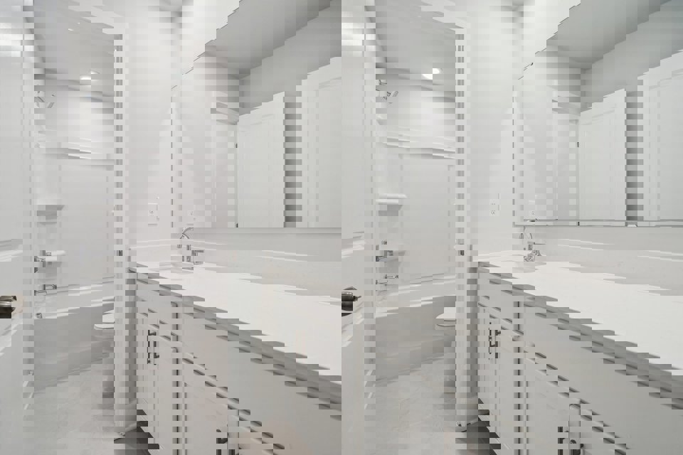 A bathroom with white cabinets.