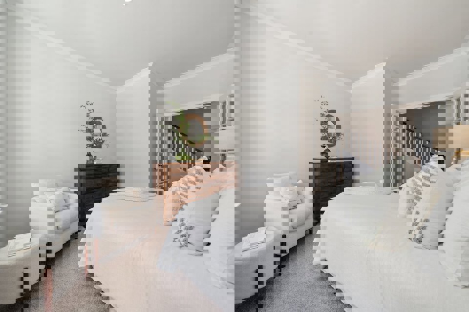 A bedroom with a bed and a chair.