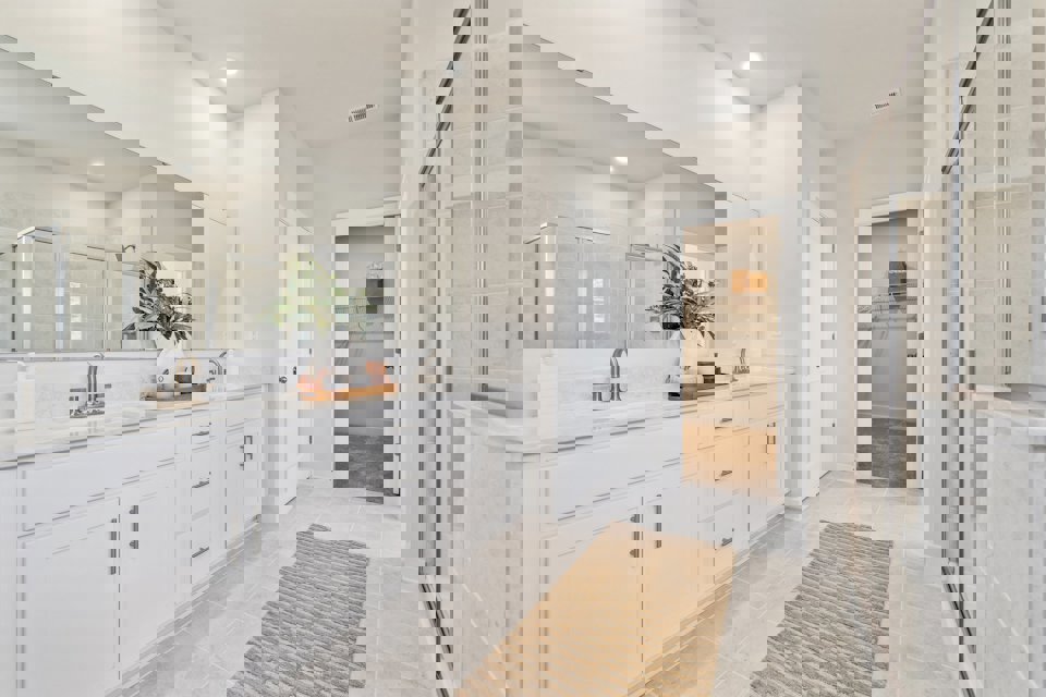 A bathroom with white cabinets.