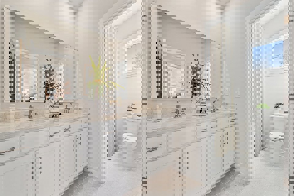 A bathroom with white cabinets.