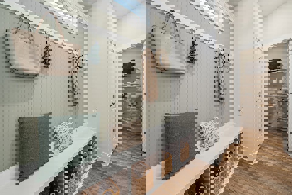 A room with a bed and a shelf with hats on it.