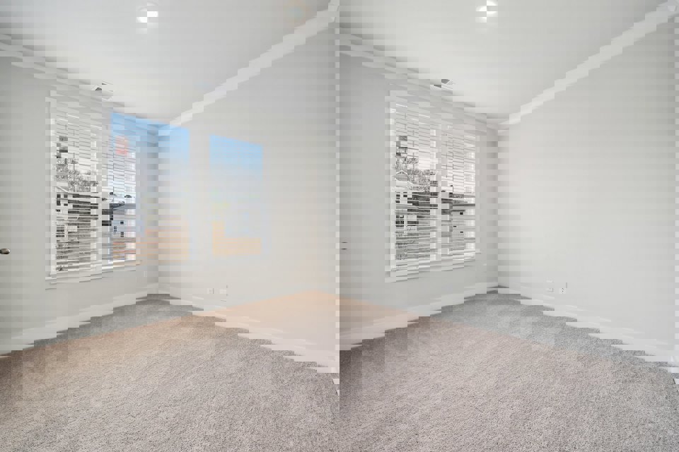 A room with a window and a carpet.