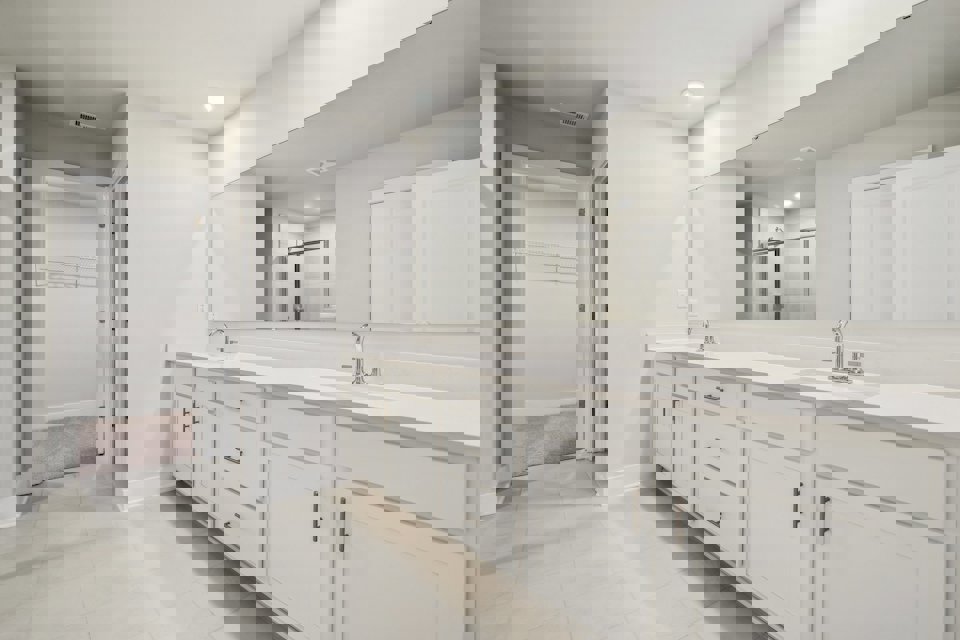 A bathroom with white cabinets.