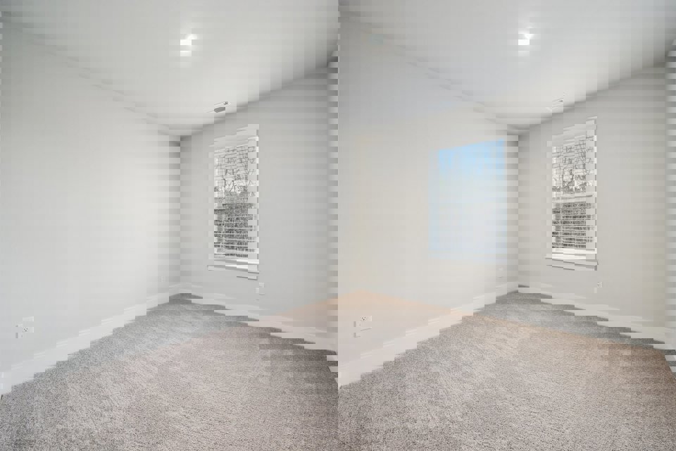 A room with a window and a carpet.