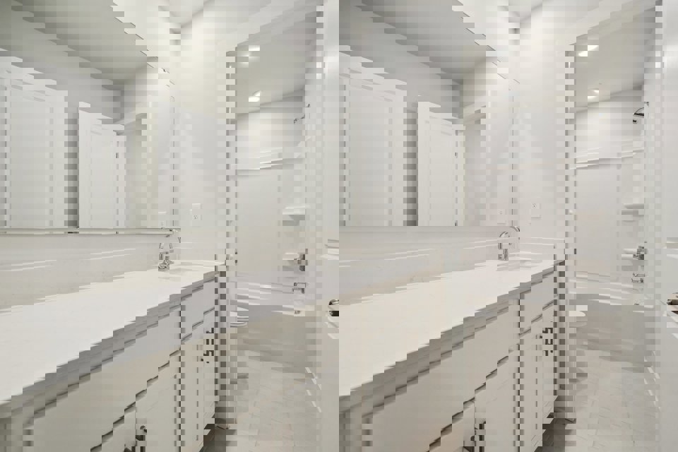 A bathroom with white cabinets.