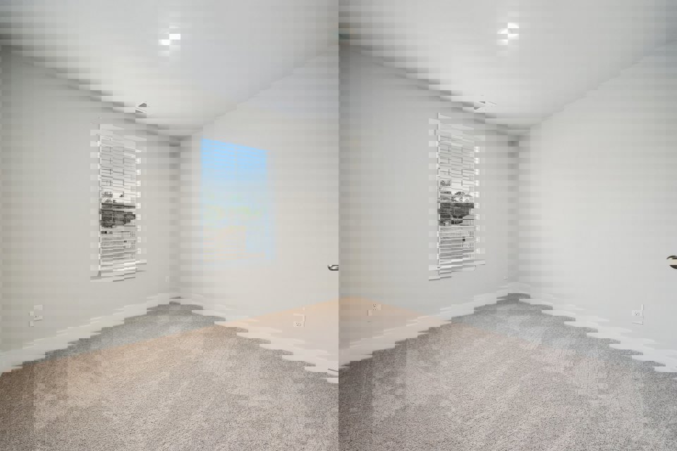 A room with a window and a carpet.