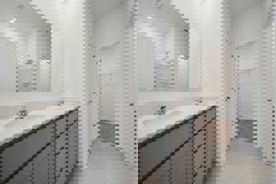 A bathroom with white cabinets.