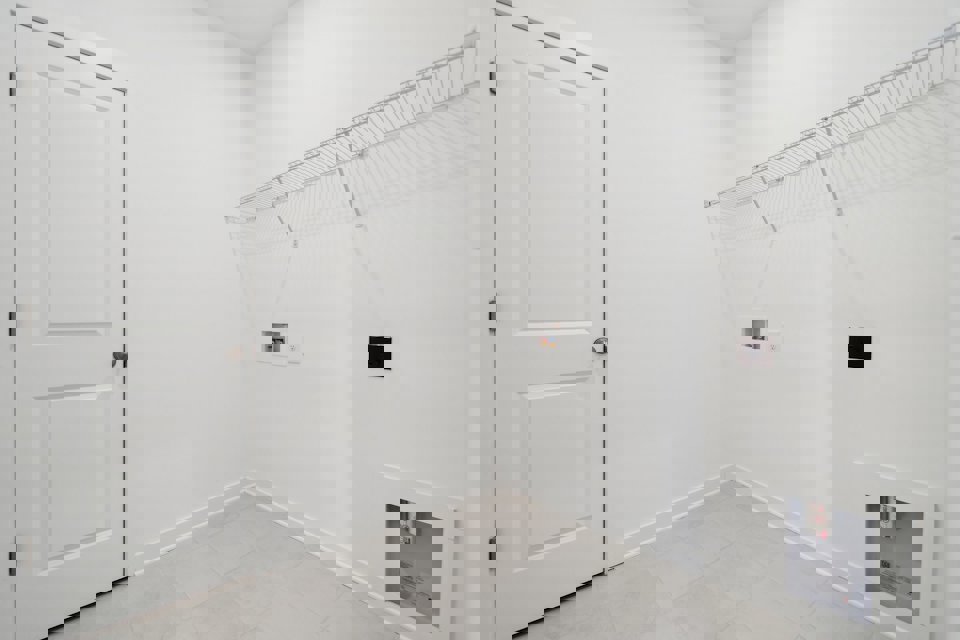 A white room with a white door and a white wall.