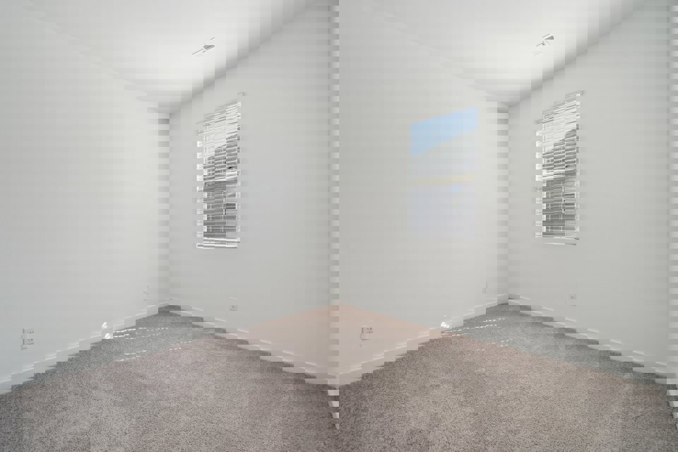 A room with a window and carpet.