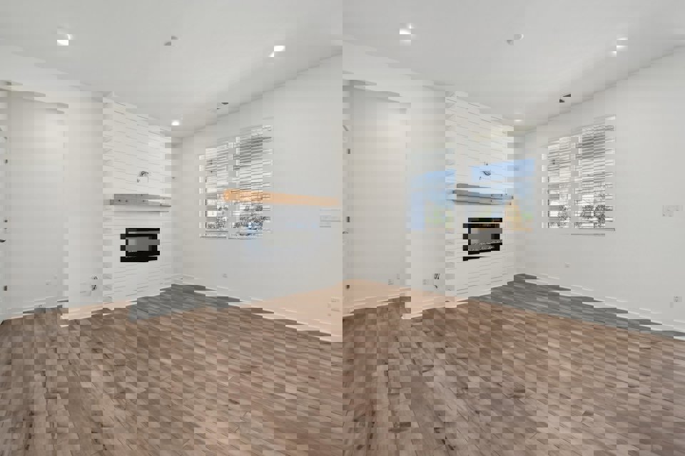 A room with a fireplace and a wood floor.