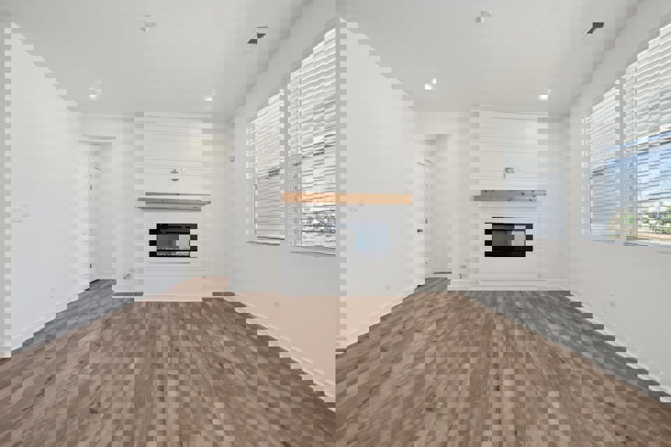 A room with a fireplace and a wood floor.