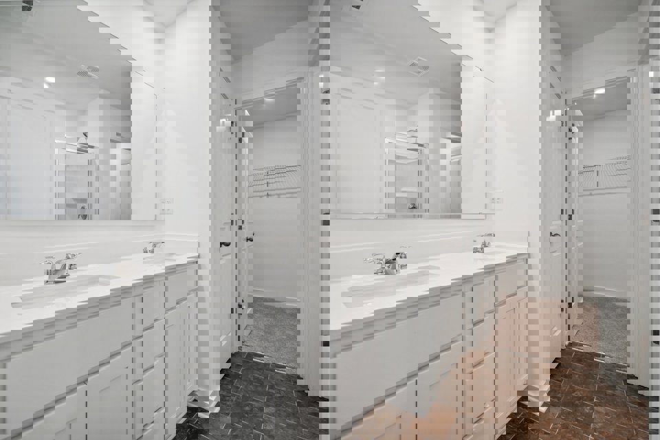 A bathroom with white cabinets.