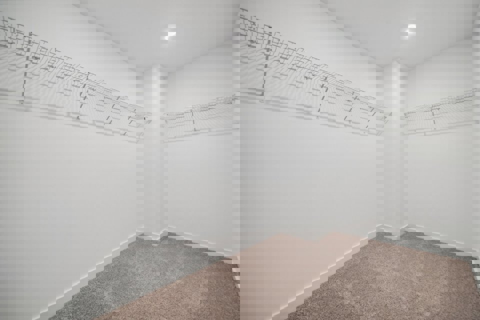 A room with a carpet and a metal railing.