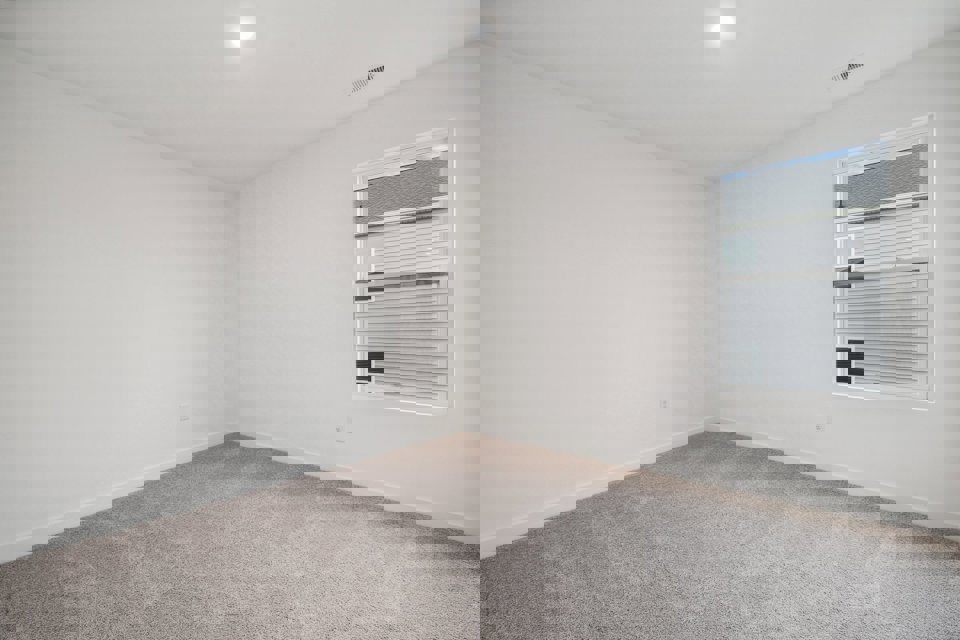 A room with a window and a carpet.