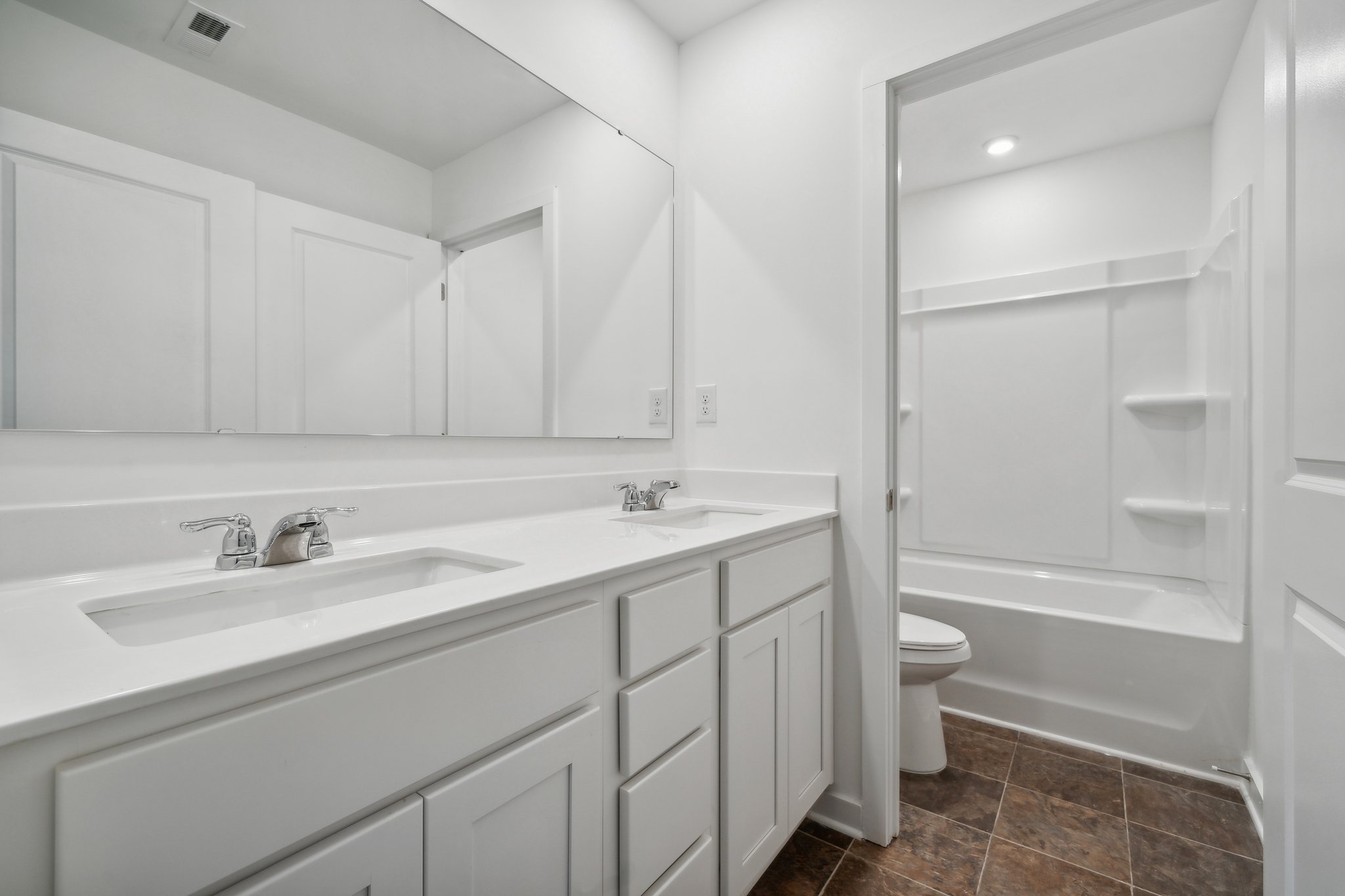 A bathroom with white cabinets.