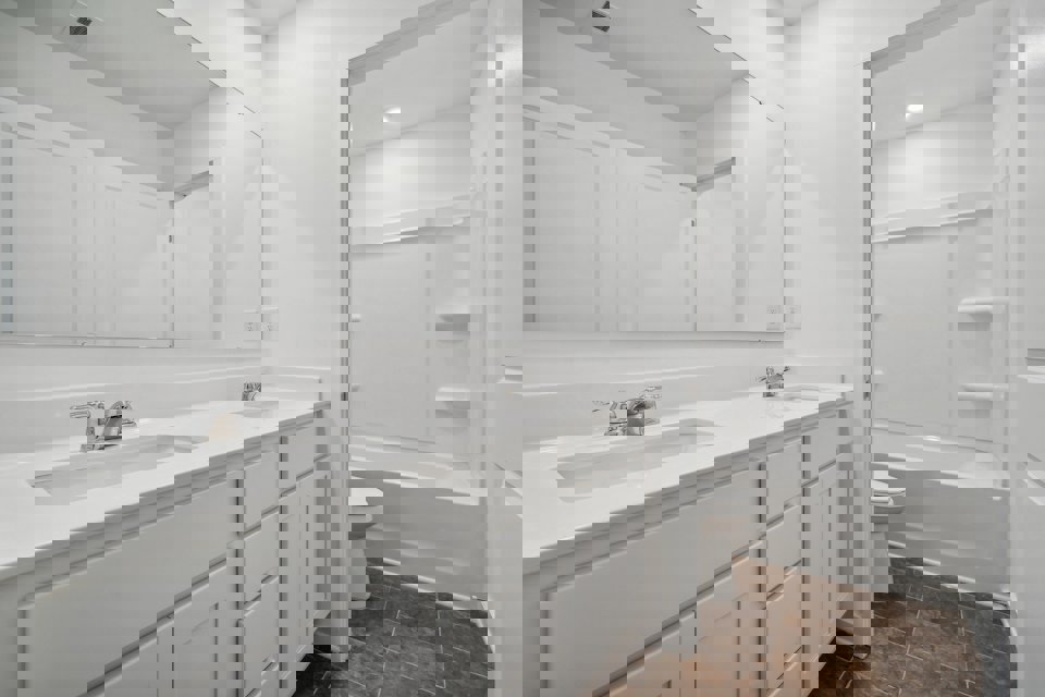 A bathroom with white cabinets.