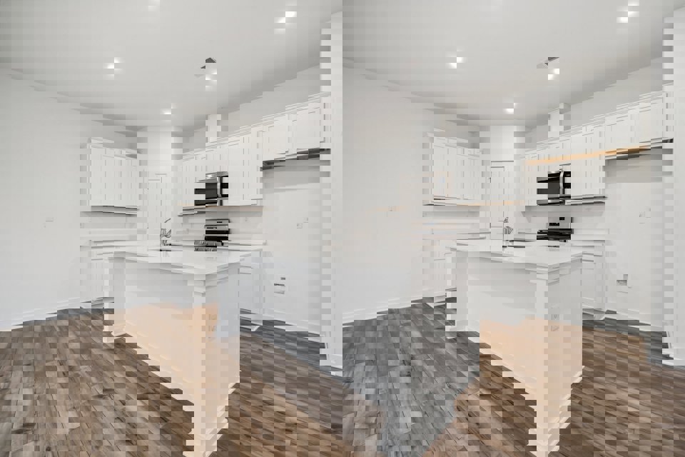 A kitchen with white cabinets.