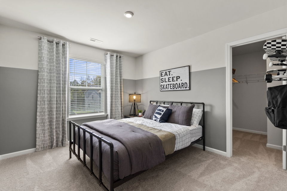 A bedroom with a bed and a lamp.