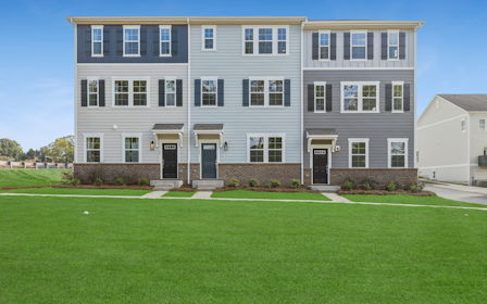 A large white building with a lawn in front of it.