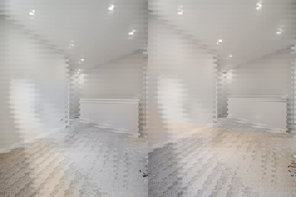 A room with a white wall and a wood floor.