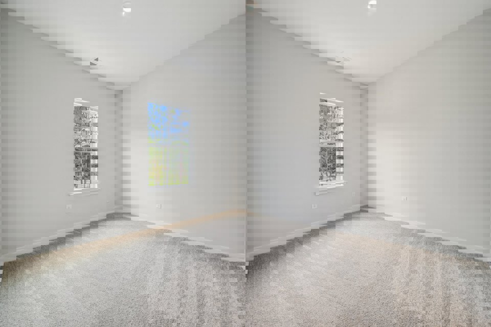 A room with a window and carpet.