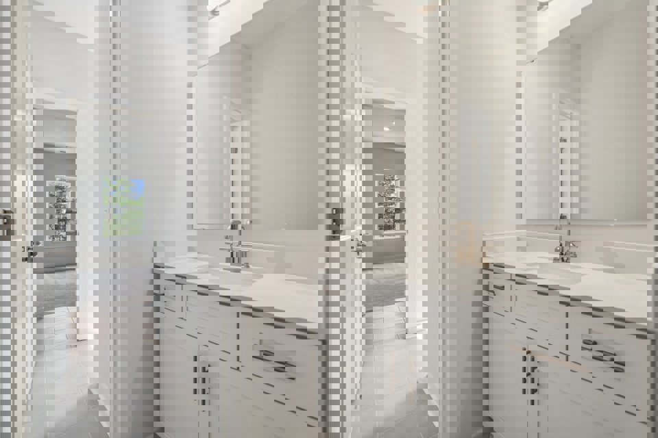 A bathroom with white cabinets.