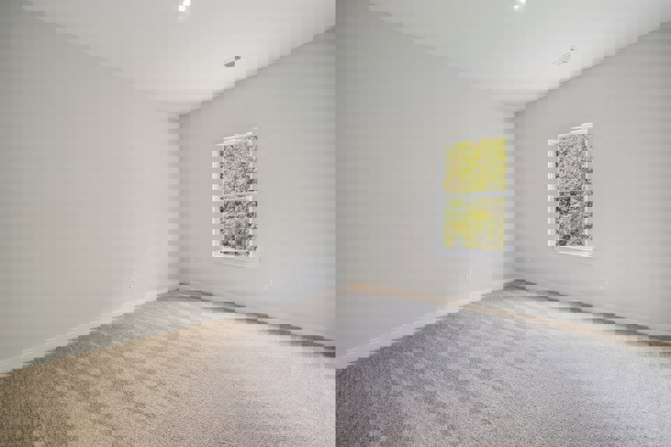 A room with a window and carpet.