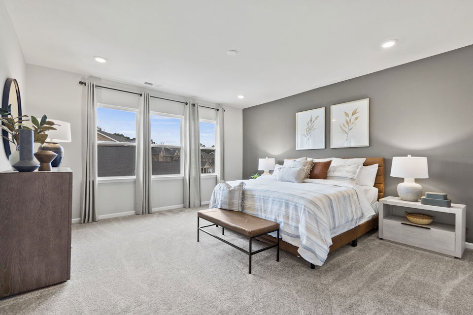 A bedroom with a bed and a table.