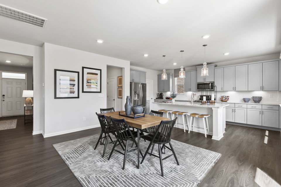 A kitchen with a dining table and chairs.