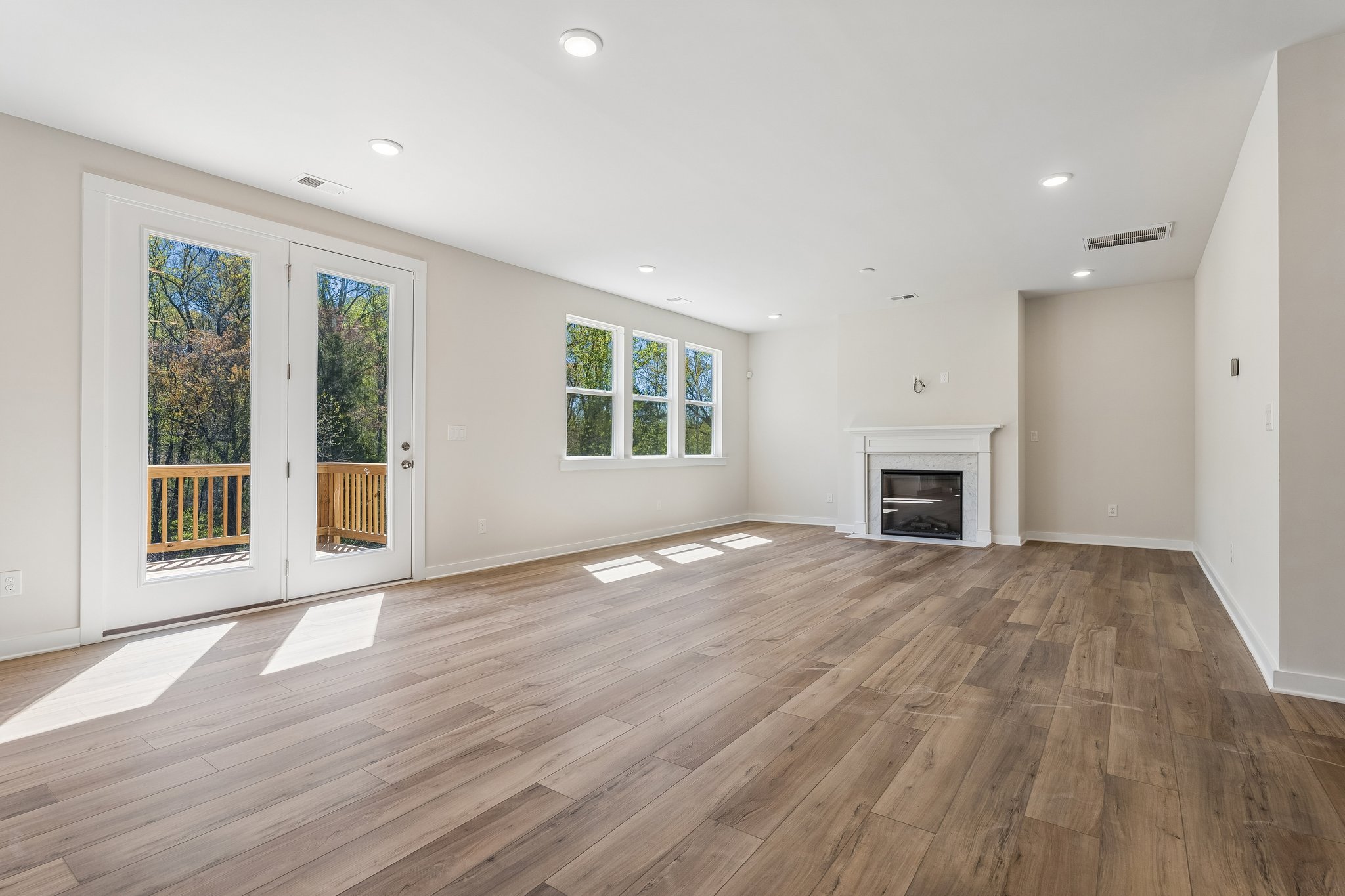 A room with a wood floor and a fireplace.