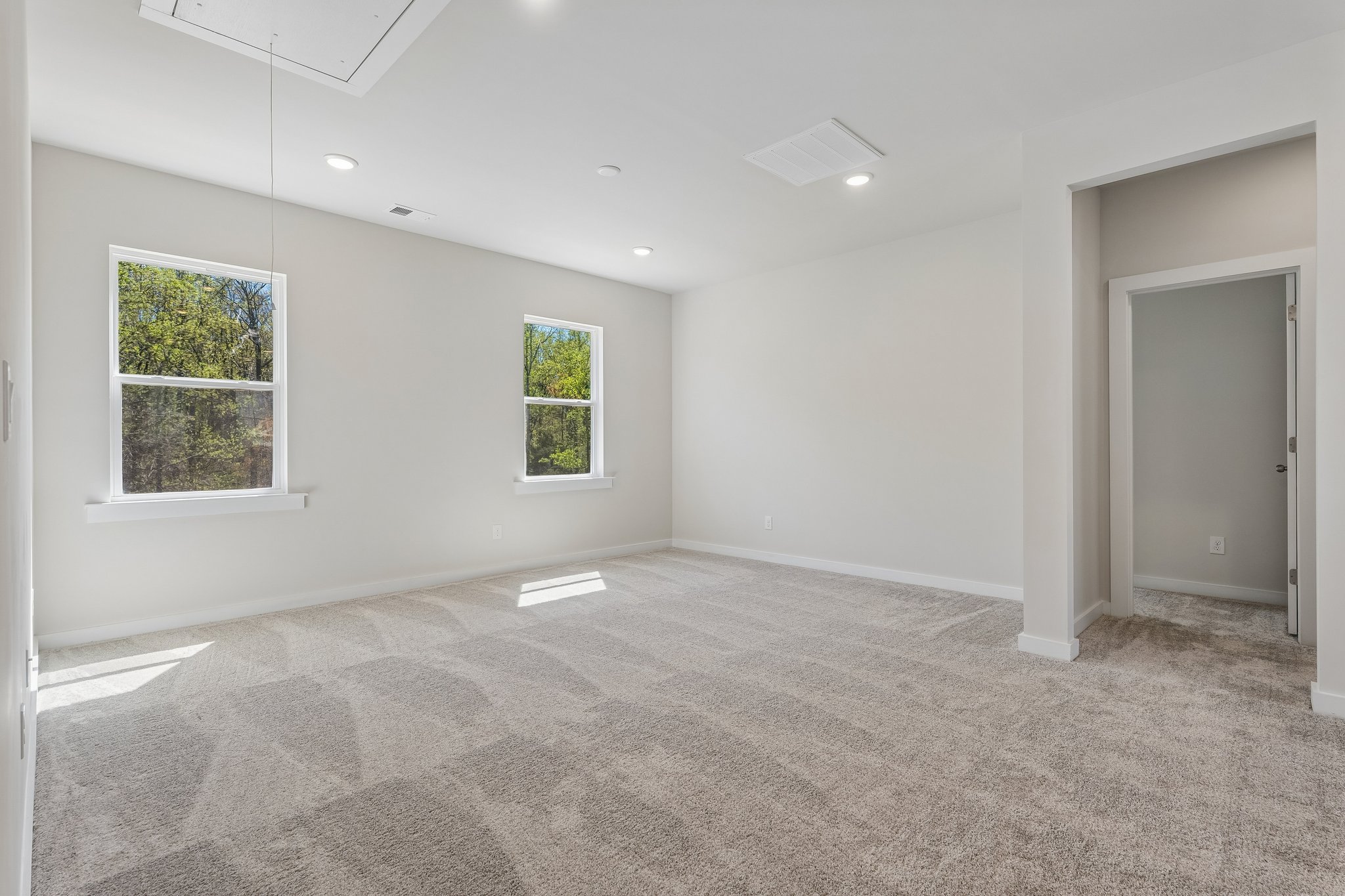 A room with a carpet and windows.