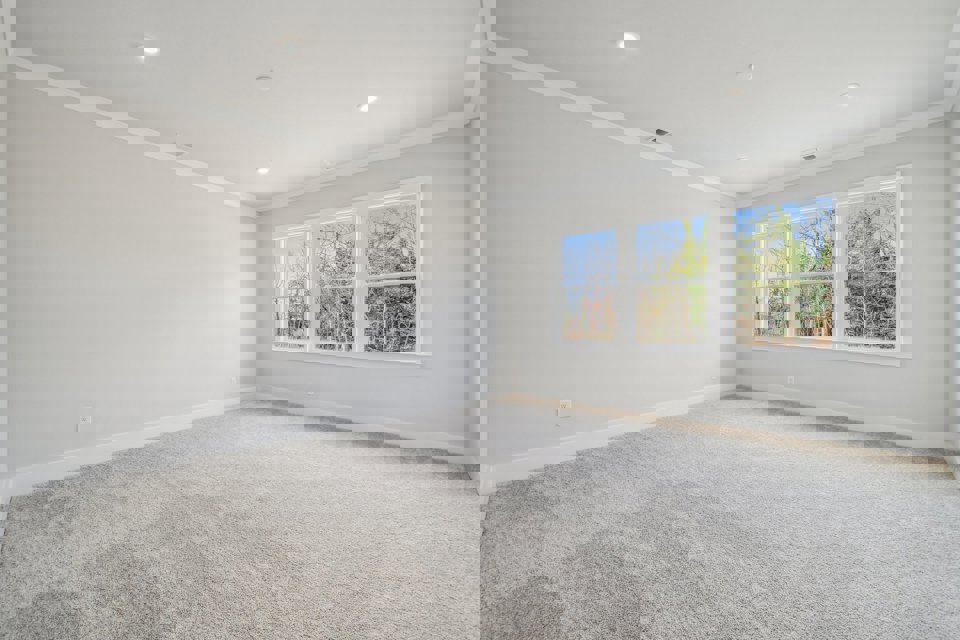 A room with a window and a carpet.