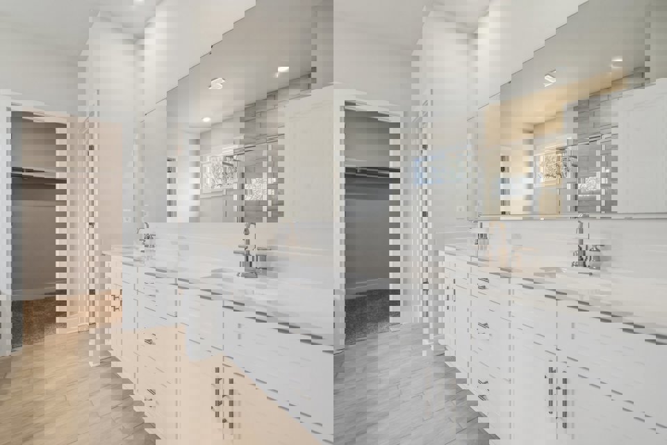 A bathroom with white cabinets.