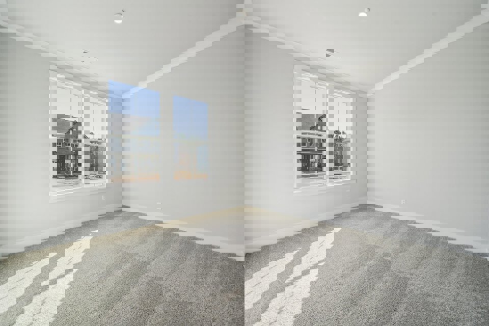 A room with a window and a rug.