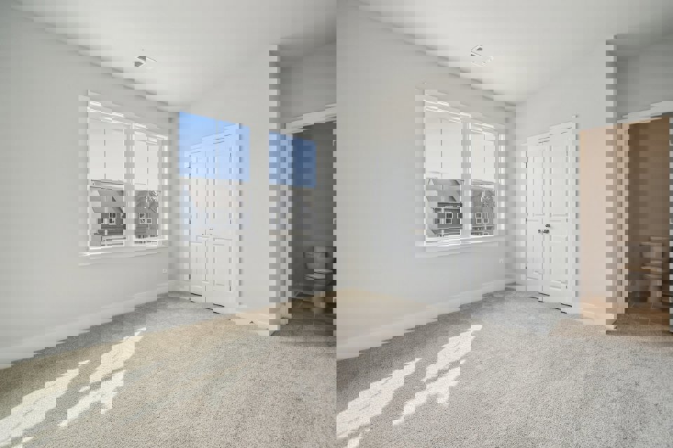 A large white room with a toilet and a window.