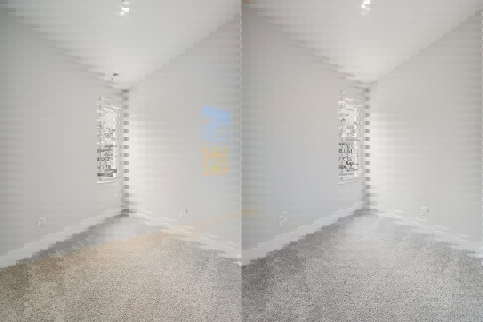 A room with a window and carpet.