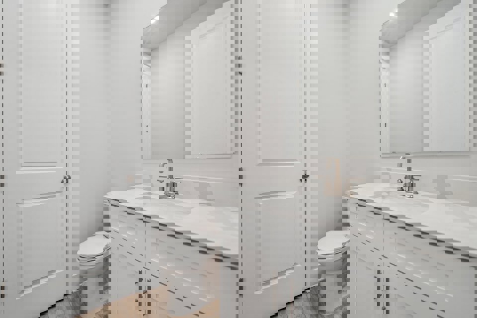 A bathroom with white cabinets.